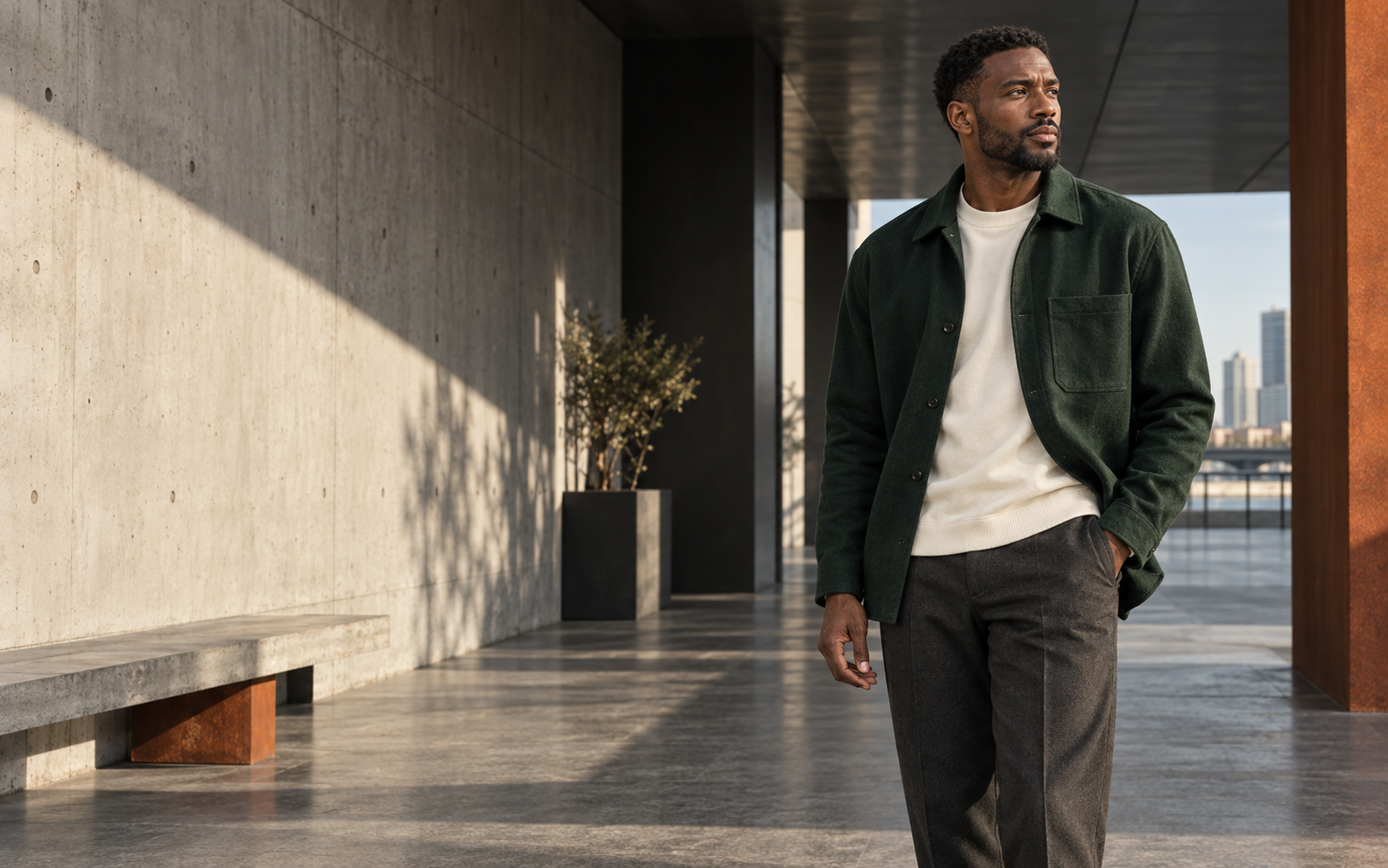 Model wearing a forest green overshirt in a modern architectural setting